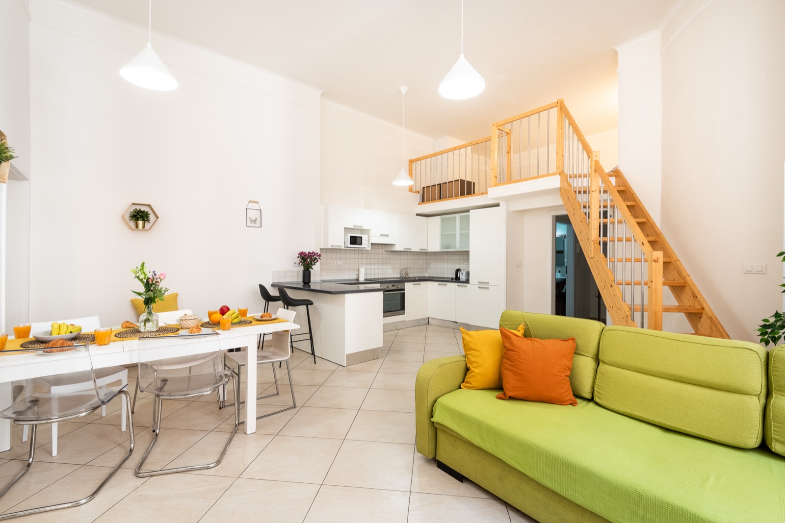 Apartmán H03 — otevřený obývací prostor s kuchyní a schody do patra