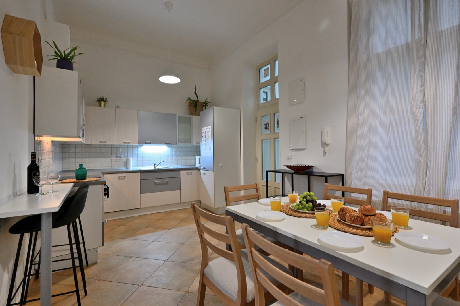 Apartmán H07 — prostorná bílá kuchyně s jídelním stolem